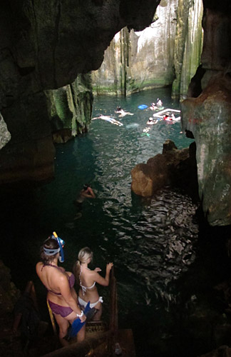 Swimmers descend the stairs into the first cave