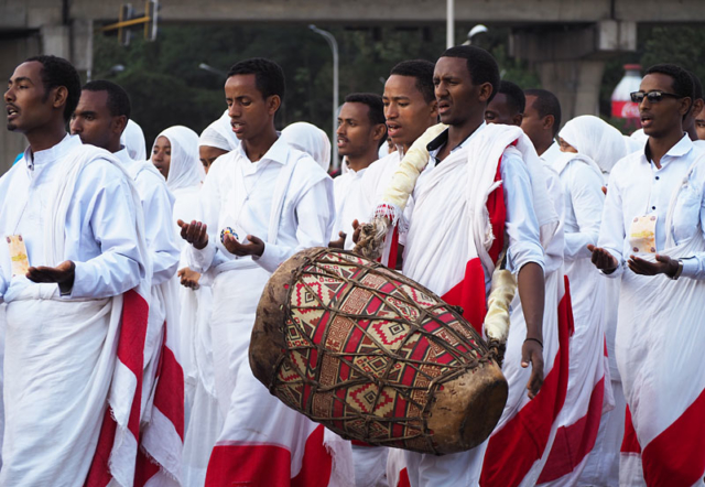 A celebrant plays a traditional doubled-headed drum called a kebero.