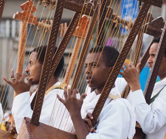 A boy concentrates as he plays the begena, a traditional harp.
