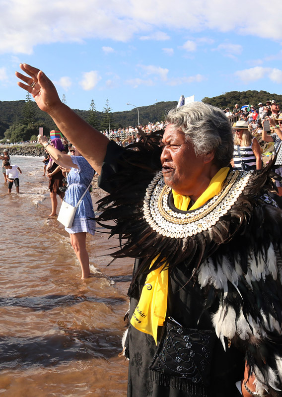 Kuia Ngaire Apiata recites a karanga (call) as the waka depart Tii Beach