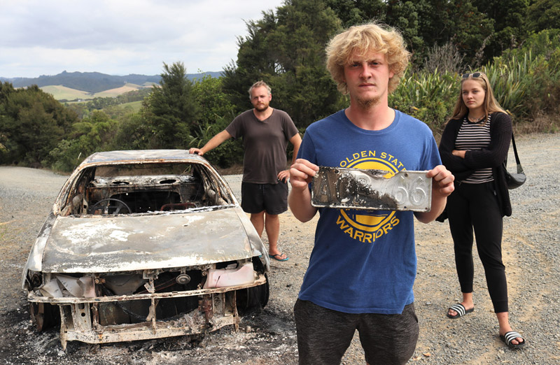 MARCH: German backpacker Marvin Rieger with all that was left of his car after it was stolen and torched at Paihia. Photo: Peter de Graaf