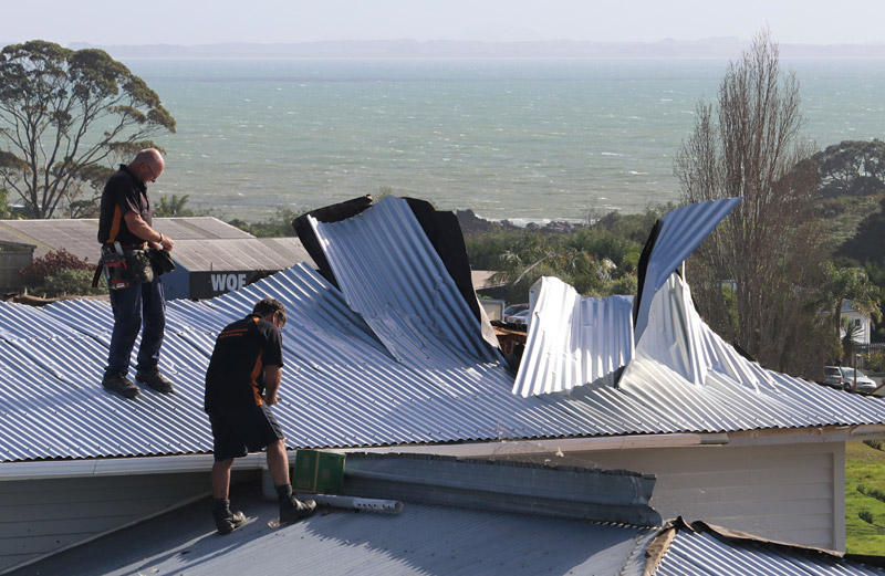 JUNE: Workers repair a roof damaged when a tornado hit Coopers Beach. Photo: Peter de Graaf