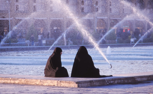 Women in chador relax by a fountain on Esfahan’s Iman Square