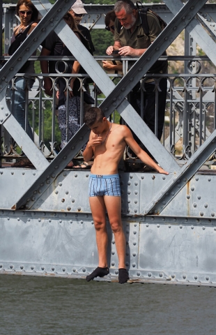 A boy clad only in socks ands boxers plucks up courage before jumping from a bridge in Porto