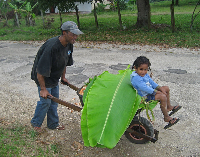 Sione Vailea takes his nephew for a ride in a wheelbarrow in Houma village, Tongatapu