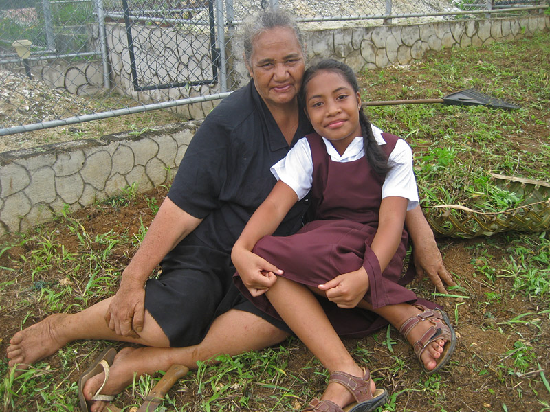 A girl and her grandmother rest after weeding a cemetery in Neiafu, Vava’u