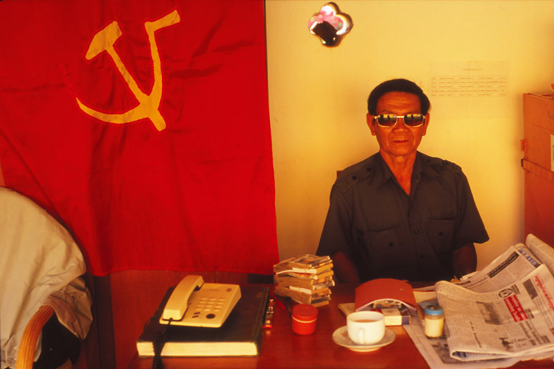 Official with communist flag at Pha That Luang, Vientiane