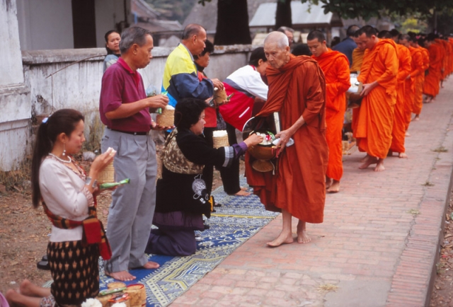 Devout Buddhists offer monks alms of sticky rice at dawn in Luang Prabang