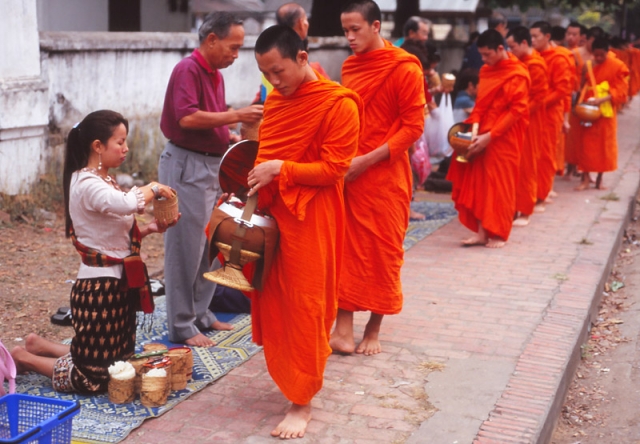 Devout Buddhists offer monks alms of sticky rice at dawn in Luang Prabang