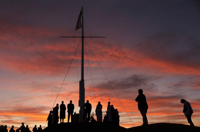 March: The sun rises behind Russell’s Flagstaff Hill during commemorations of the 175th anniversary of the Battle of Kororāreka. Photo: Peter de Graaf