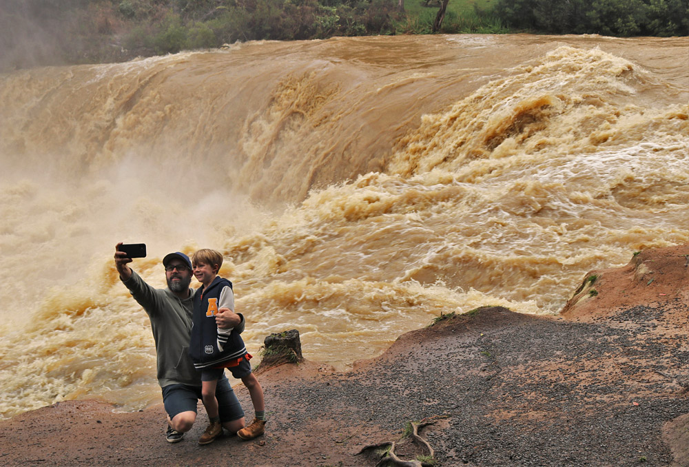 July: Hamish Macbeth and son Harrison, 6, grab a selfie at the flooded Haruru Falls near Paihia. Photo: Peter de Graaf