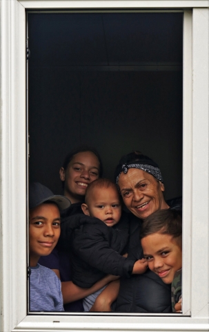December: Rachel Tana and her mokopuna [grandchildren] are framed in the window of her cabin home. Photo: Peter de Graaf