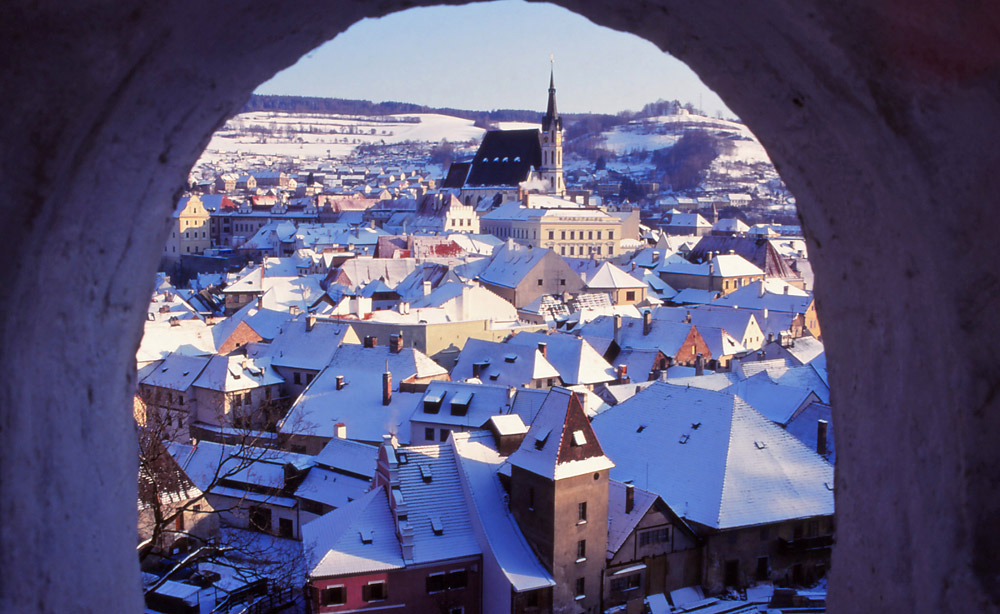 The medieval town of Český Krumlov is framed by a window in the castle garden walls