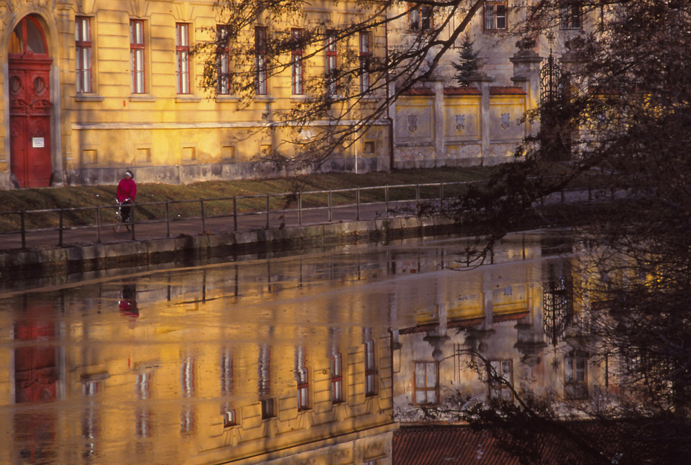 Česká High School is reflected in a partly frozen Malše River, České Budějovice
