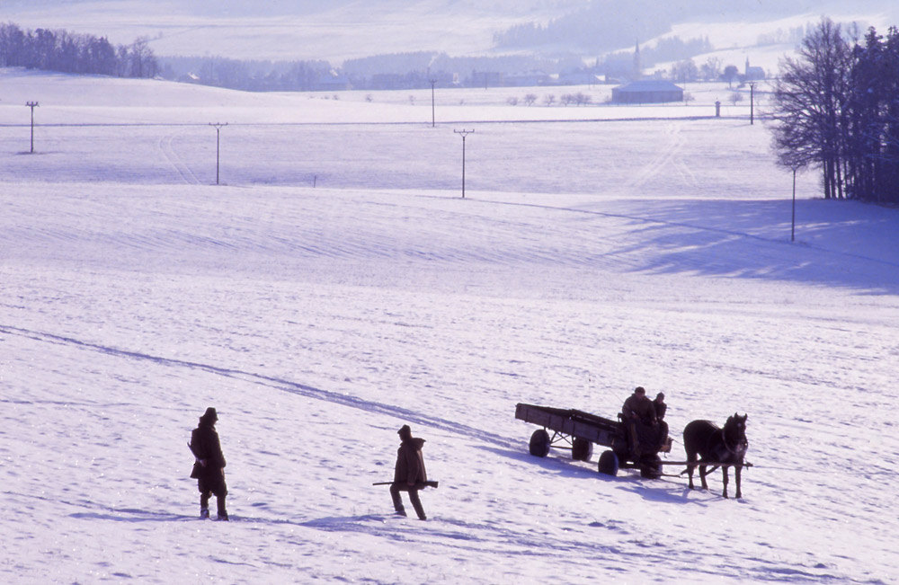 Hunters and a horse-drawn cart in a wintry South Bohemian landscape