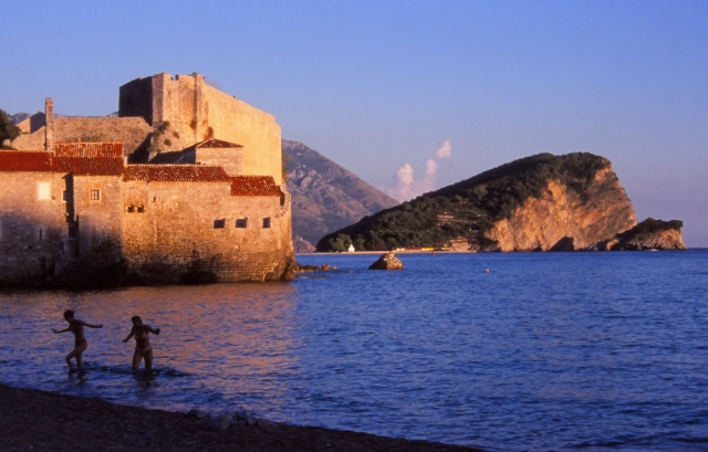 Montenegro, 1999: Swimmers emerge from the sea next to the ancient walled city of Budva