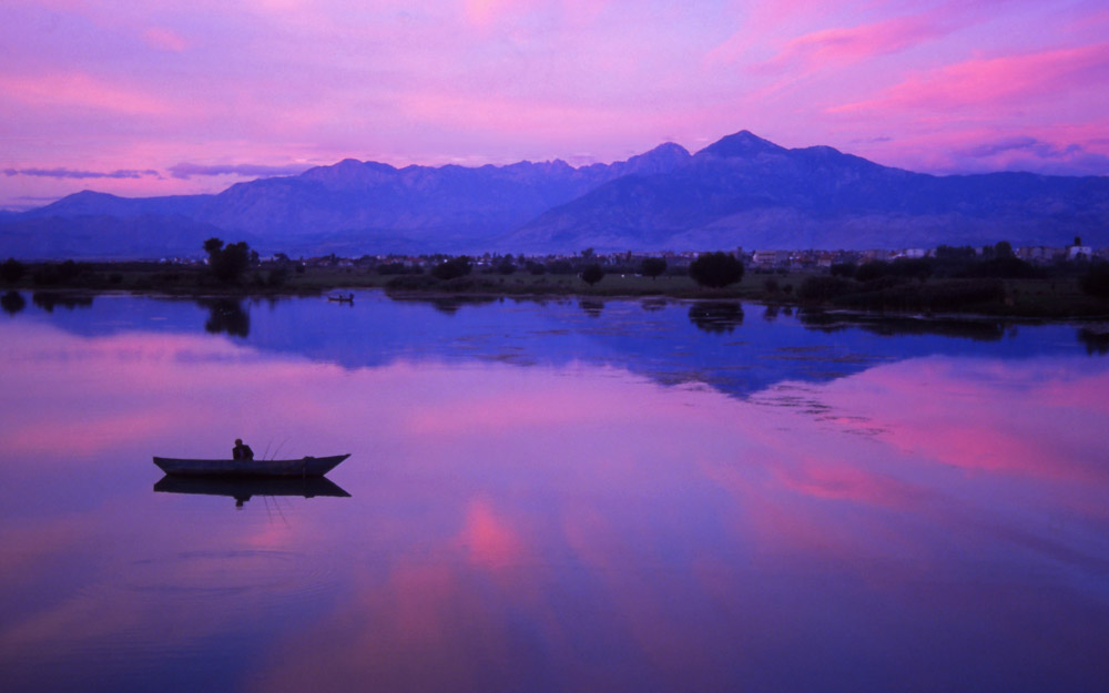 A fisherman tries his luck at dusk on Lake Shkodra, largest lake in the Balkans