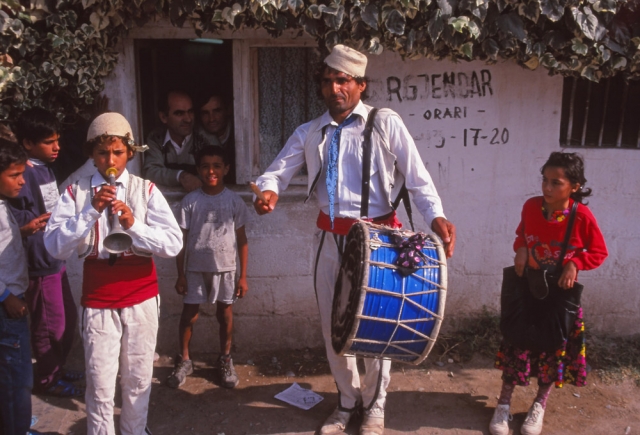 Street musicians perform outside a jeweller's shop in Elbasan