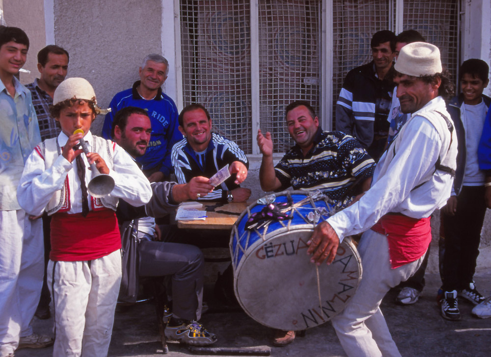 Street musicians entertain café patrons in Elbasan