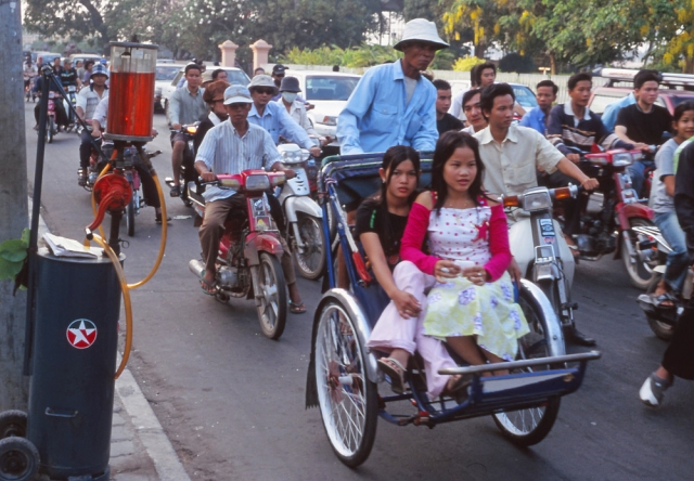 Rush hour in Phnom Penh. Note the hand-operated roadside petrol pump