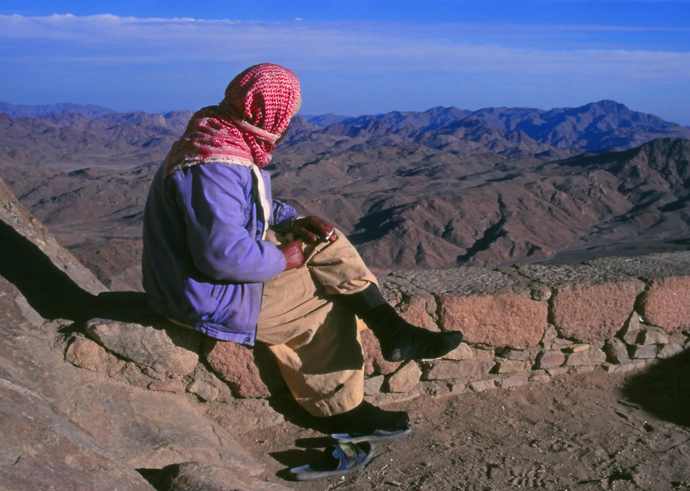 A Bedouin stall holder looks out over the Sinai Peninsula from the top of Mt Sinai