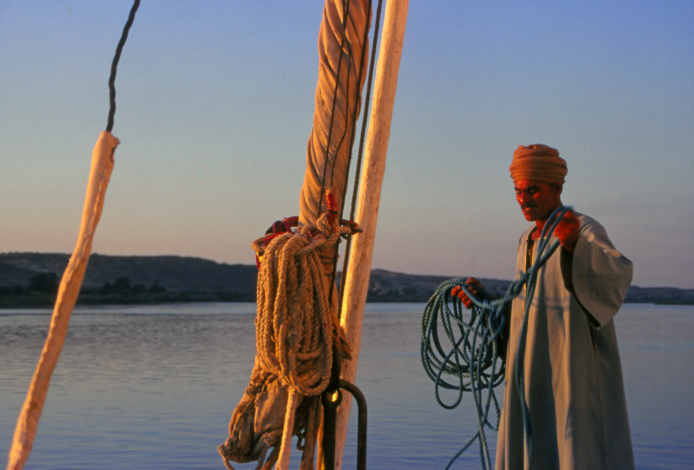 Captain Kafran takes down the sails for the night during a felucca trip down the Nile