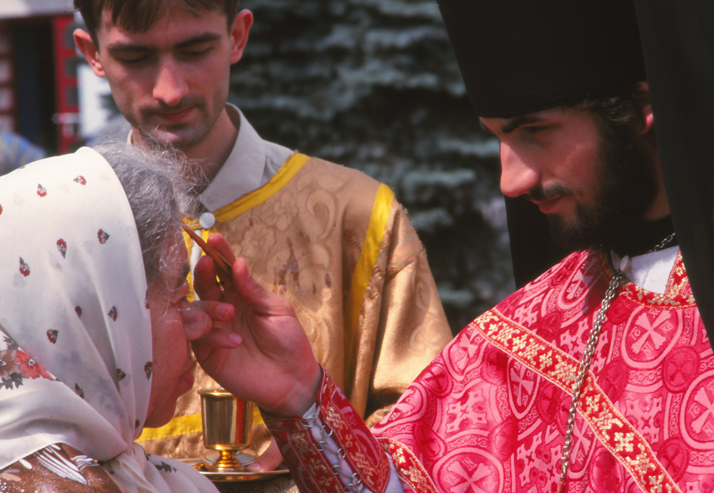 An orthodox priest blesses a woman during a religious festival in Chernivtsi